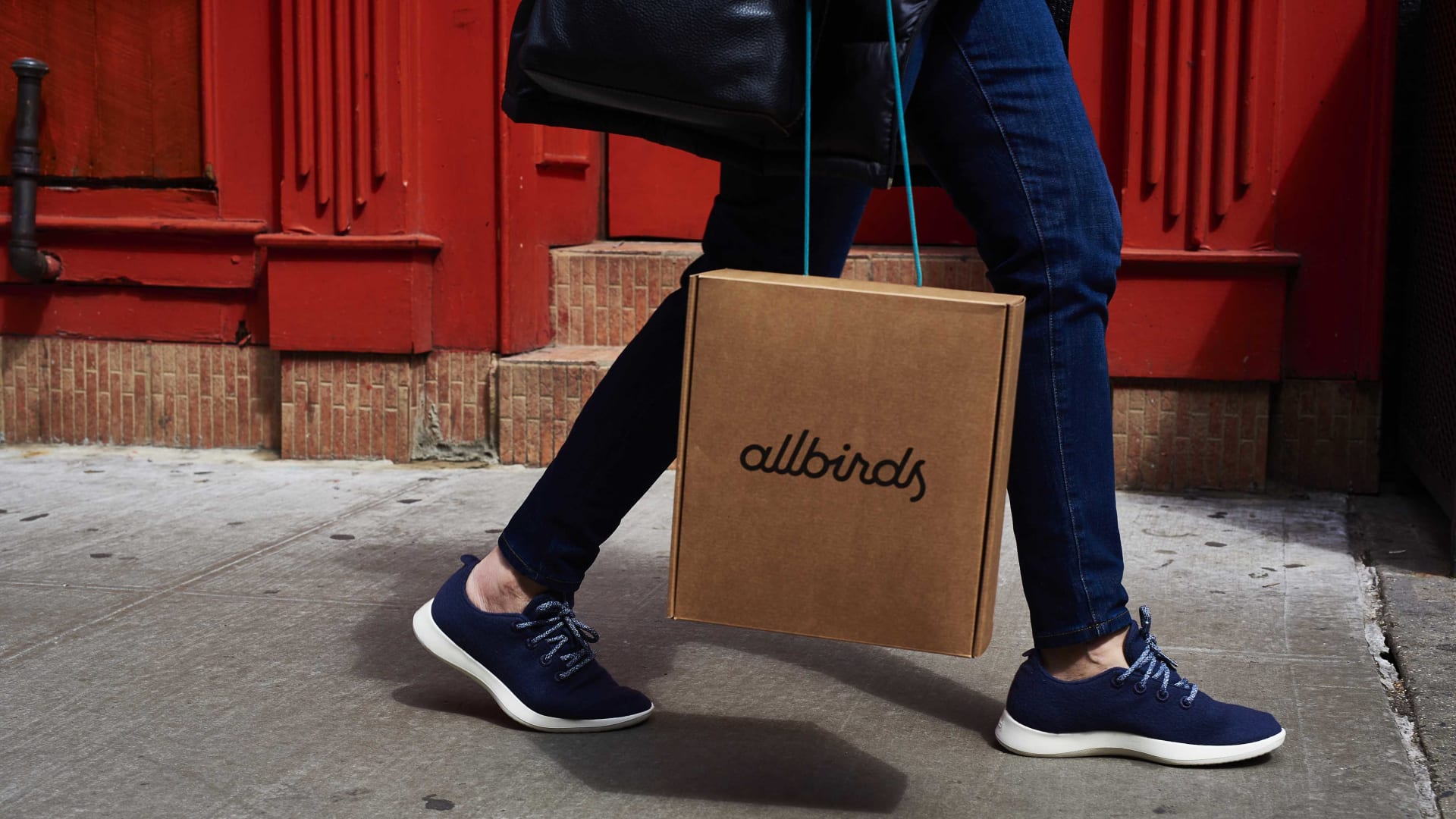 A shopper carries an Allbirds Inc. retail bag while walking in SoHo