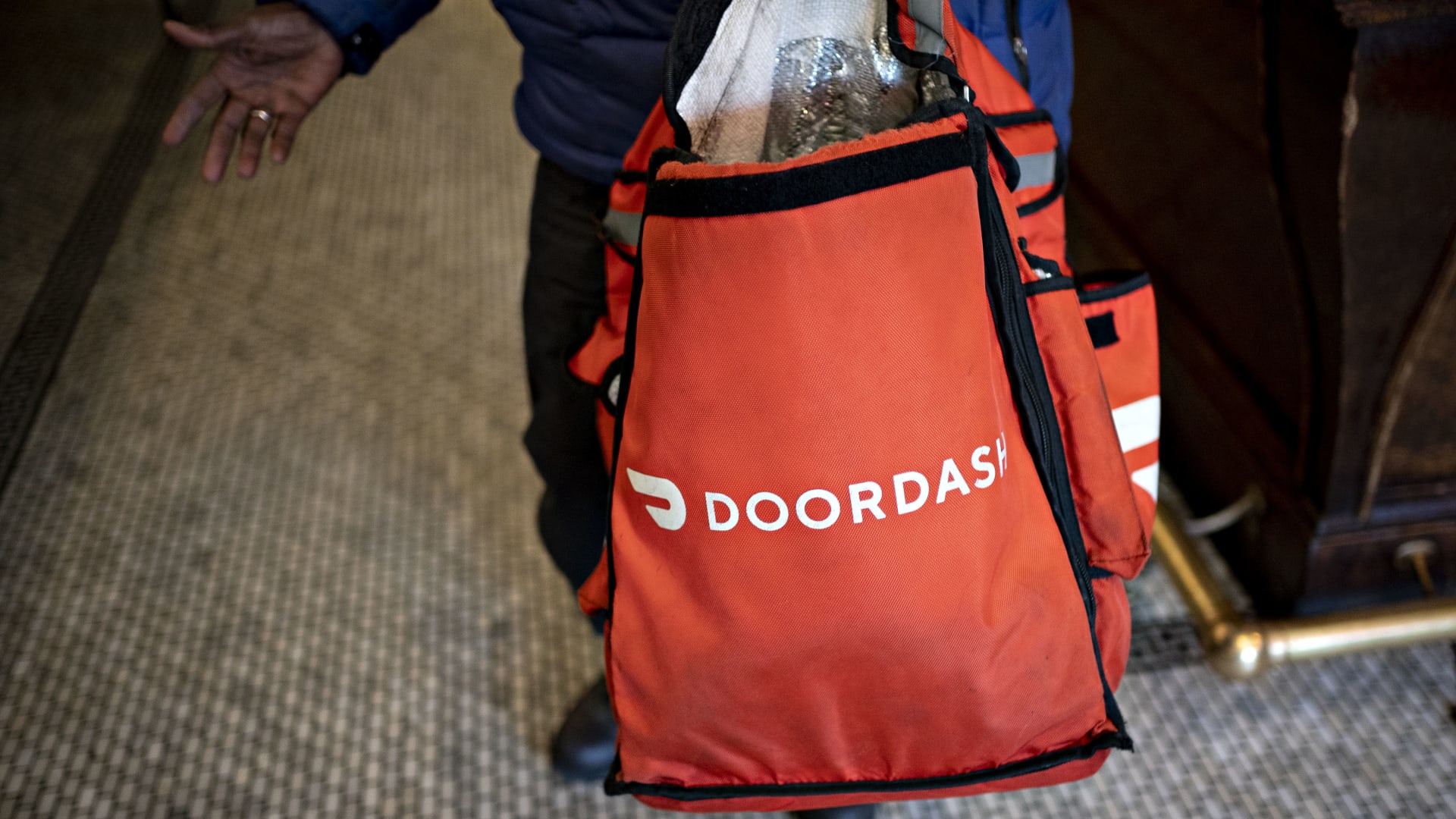 A DoorDash Inc. delivery person holds an insulated bag at a restaurant in Washington, D.C.