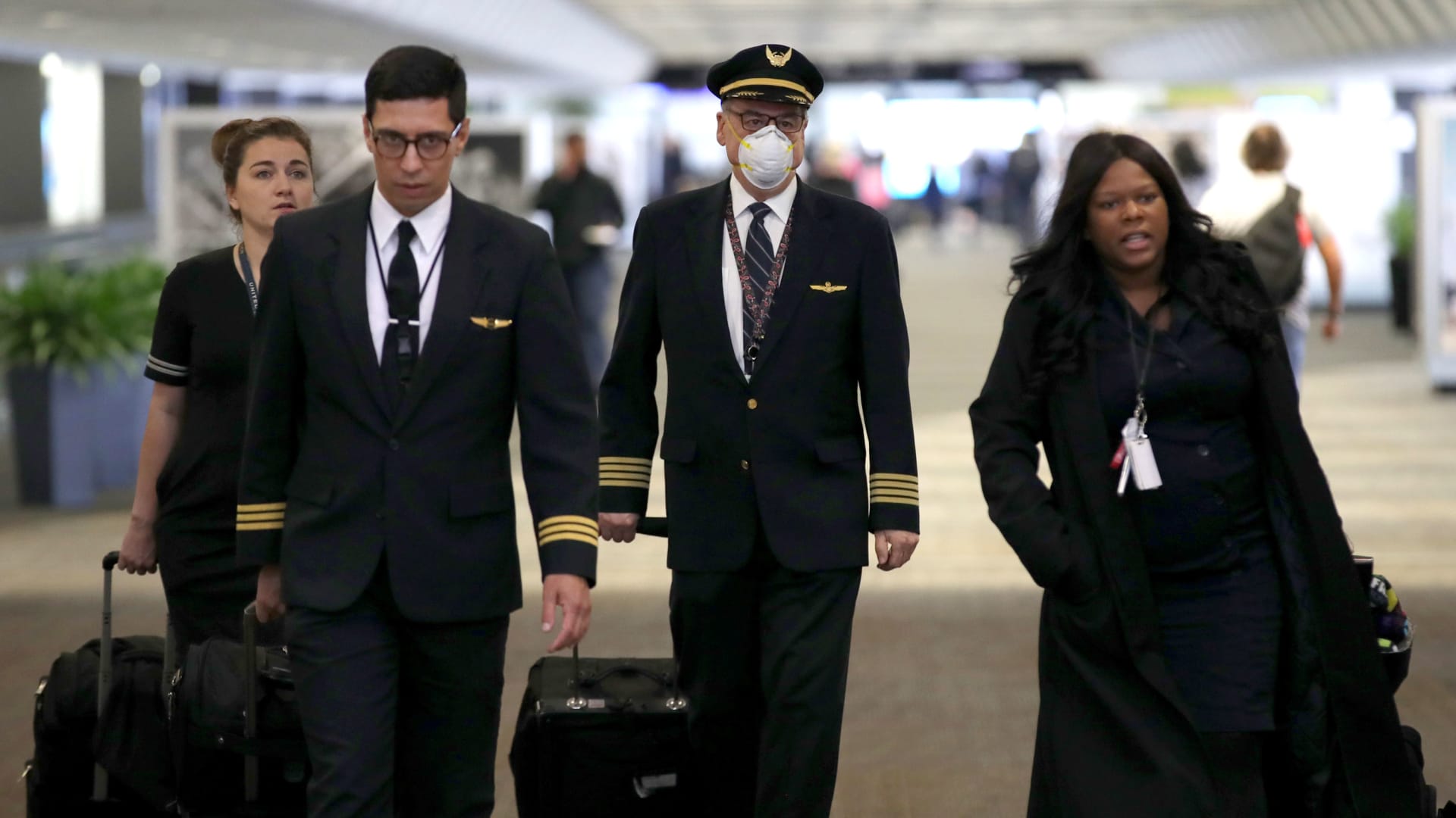 A United Airlines flight crew walks through the terminal at San Francisco International Airport. 