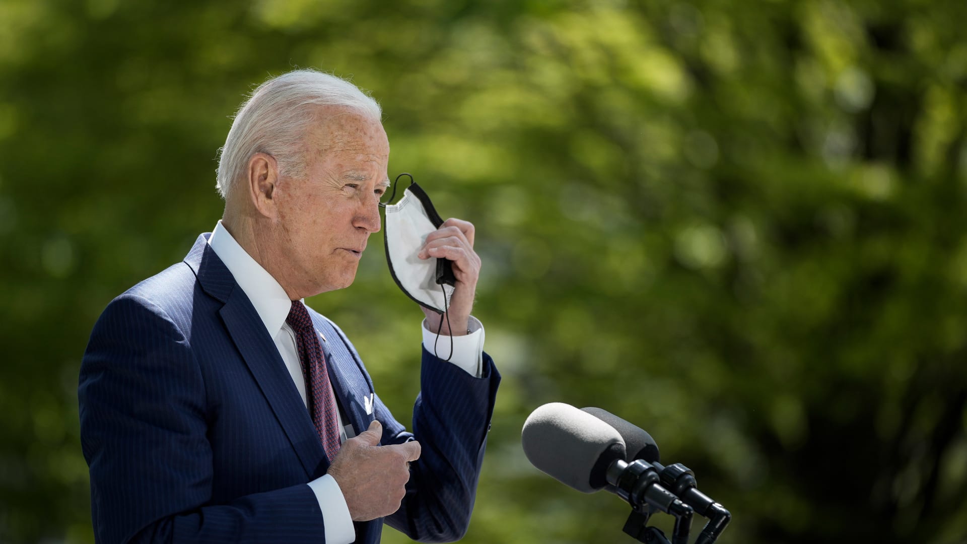 President Joe Biden removes his mask before speaking about updated CDC mask guidance on the North Lawn of the White House on April 27, 2021, in Washington, D.C. President Biden announced updated CDC guidance, saying vaccinated Americans do not need to wear a mask outside when in small groups.