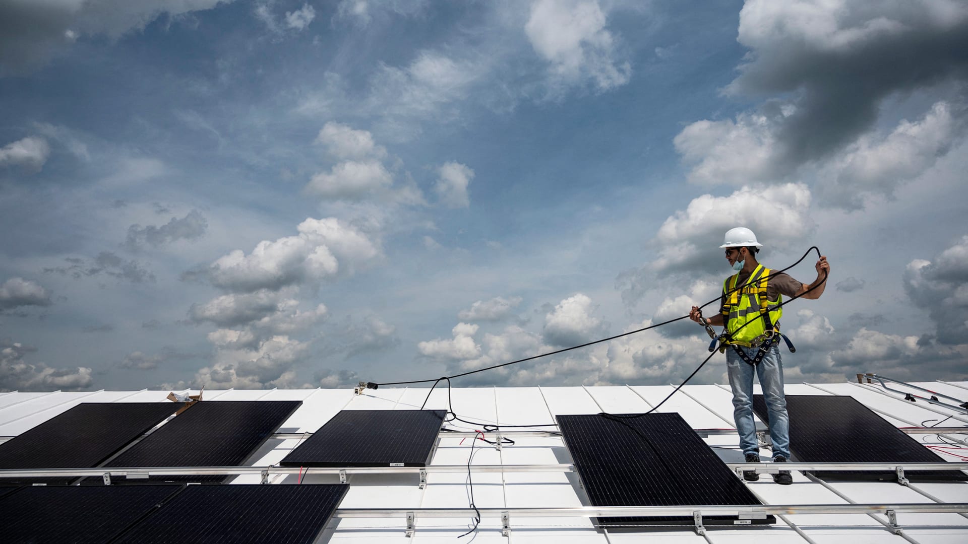 An employee with Ipsun Solar installs solar panels on the roof of the Peace Lutheran Church in Alexandria, Virginia, on May 17, 2021.