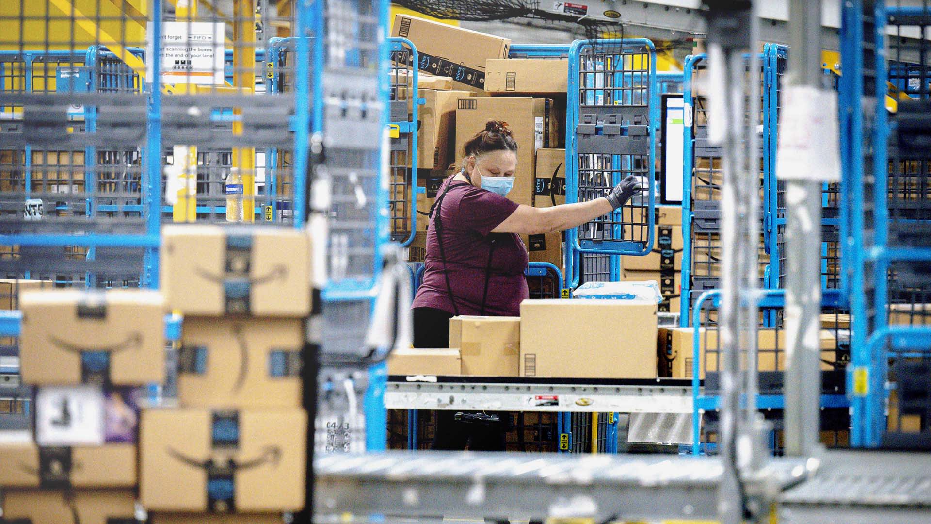 A worker sorts out packages at an Amazon fulfillment center in Eastvale, California. 