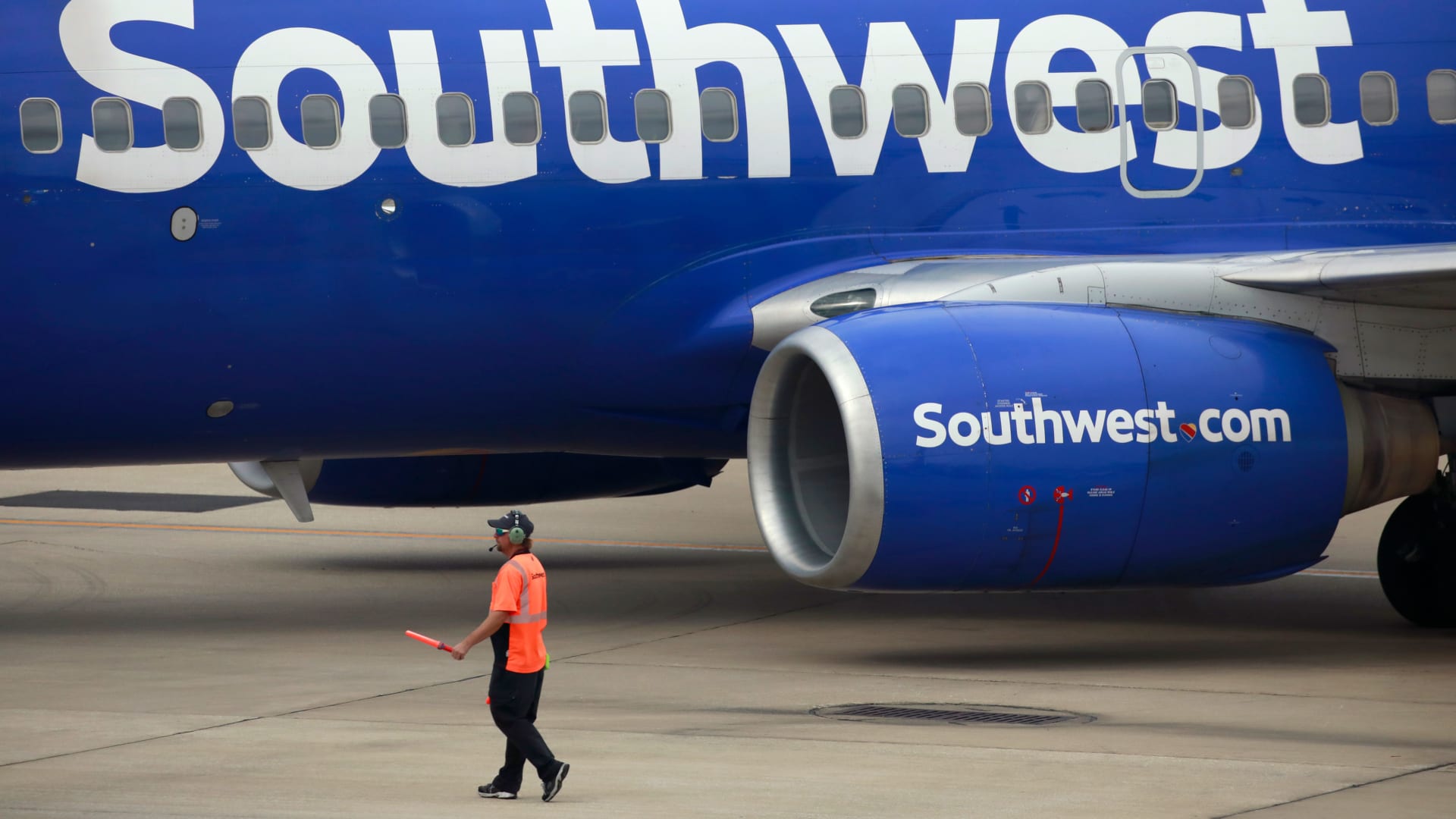 A worker directs a Southwest Airlines Boeing 737 passenger jet.
