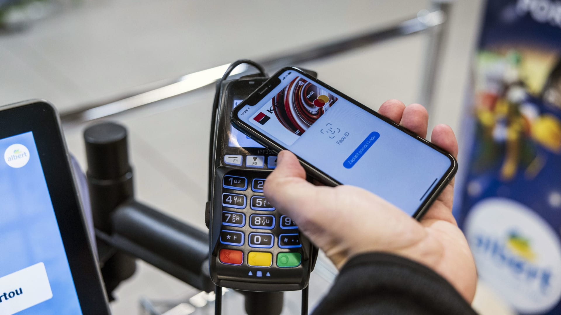 A customer uses Apple Pay at a contactless payment terminal.