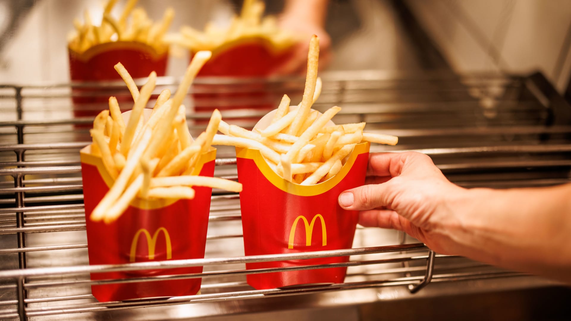 An employee handles fry orders at McDonald's.