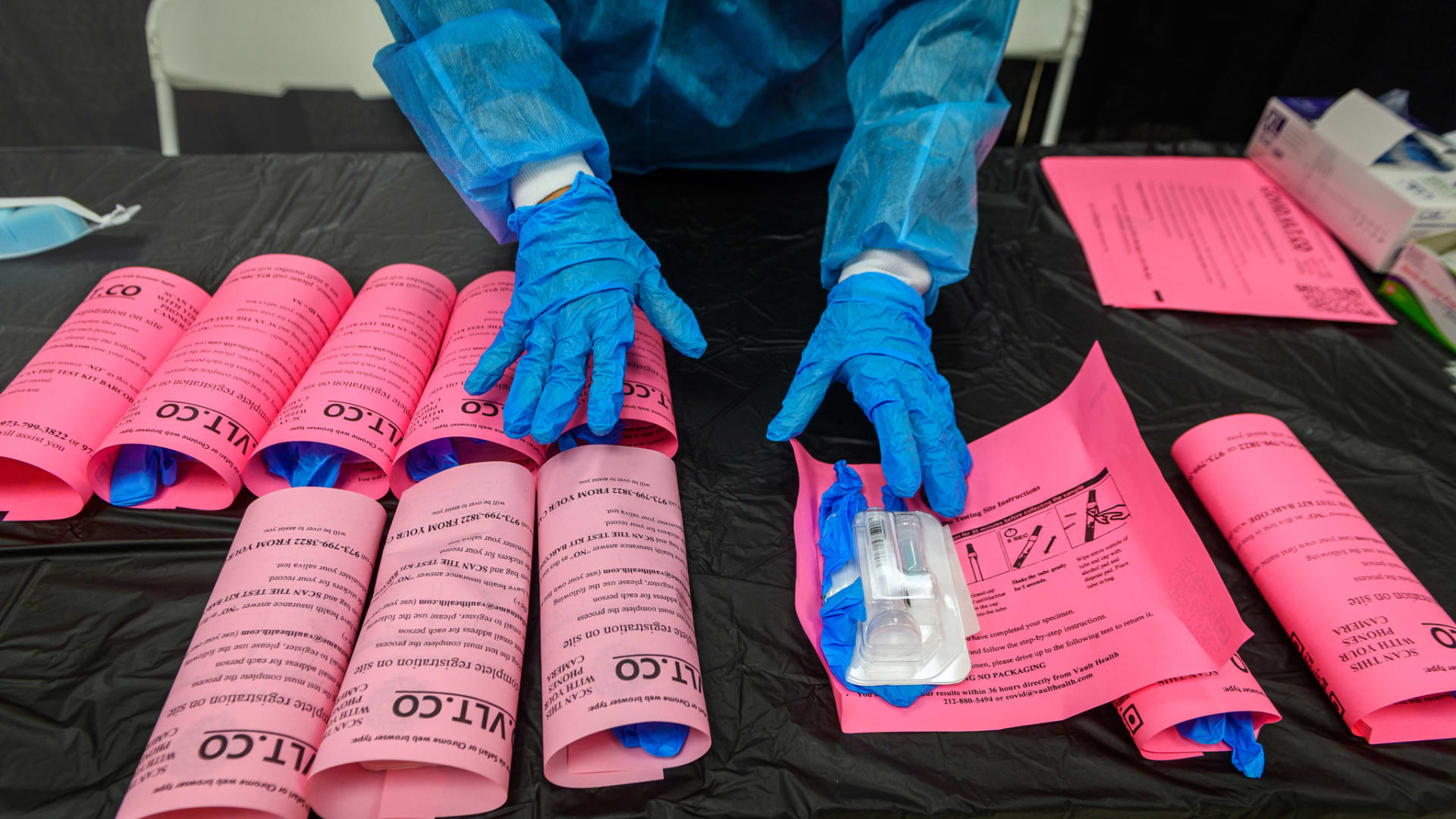 A healthcare worker arranges Covid-19 testing kits at an Essex County site in West Orange, New Jersey, on Tuesday, Dec. 21, 2021. 